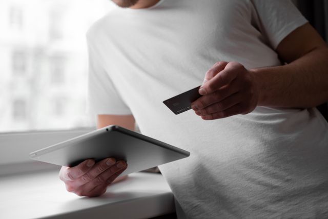 person%20holding%20a%20credit%20card%20and%20tablet