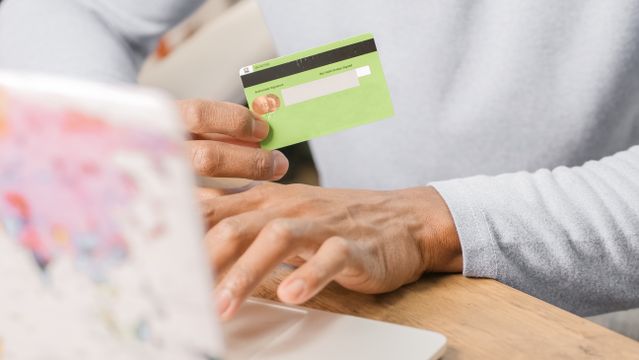 person%20on%20a%20laptop%20holding%20a%20credit%20card