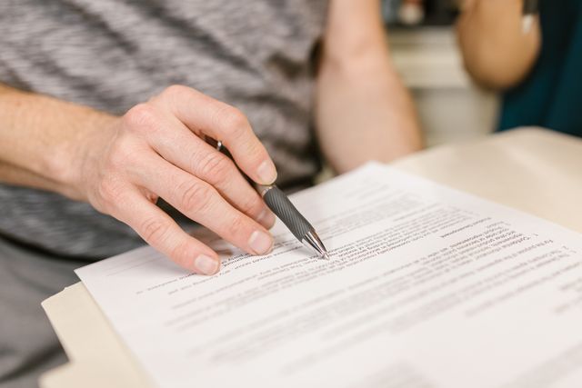 someone%20signing%20a%20document%20with%20a%20pen